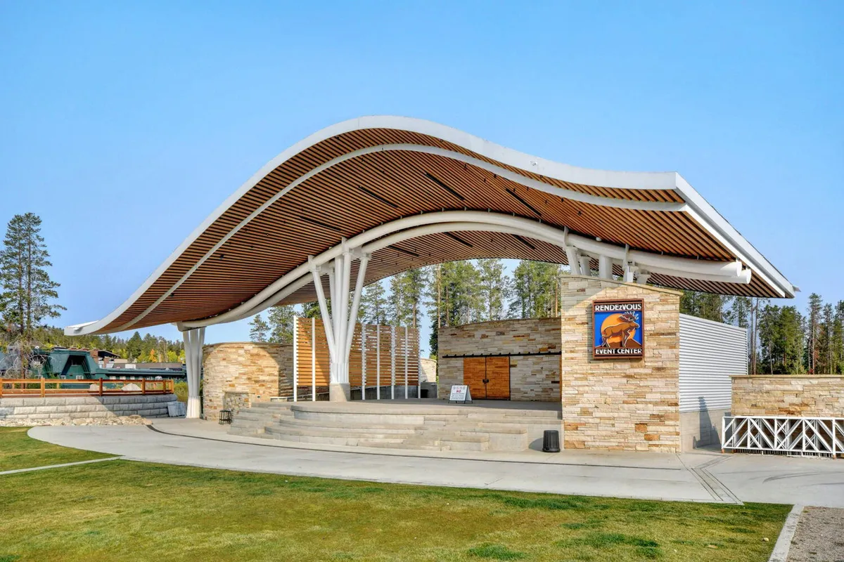 A dynamic outdoor amphitheater with a distinctive curved roof and stonework stands ready for community gatherings, concerts, and events. The stage area is the focal point, promising exciting performances and shared experiences.