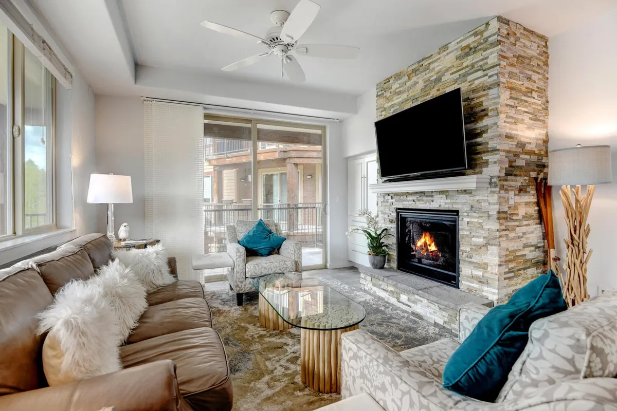 This warm living room scene highlights a cozy gas fireplace, a comfortable sofa with decorative pillows, a coffee table, and an HD smart TV. The setup invites relaxation, socializing, and family entertainment, mirroring the atmosphere described in the section content.